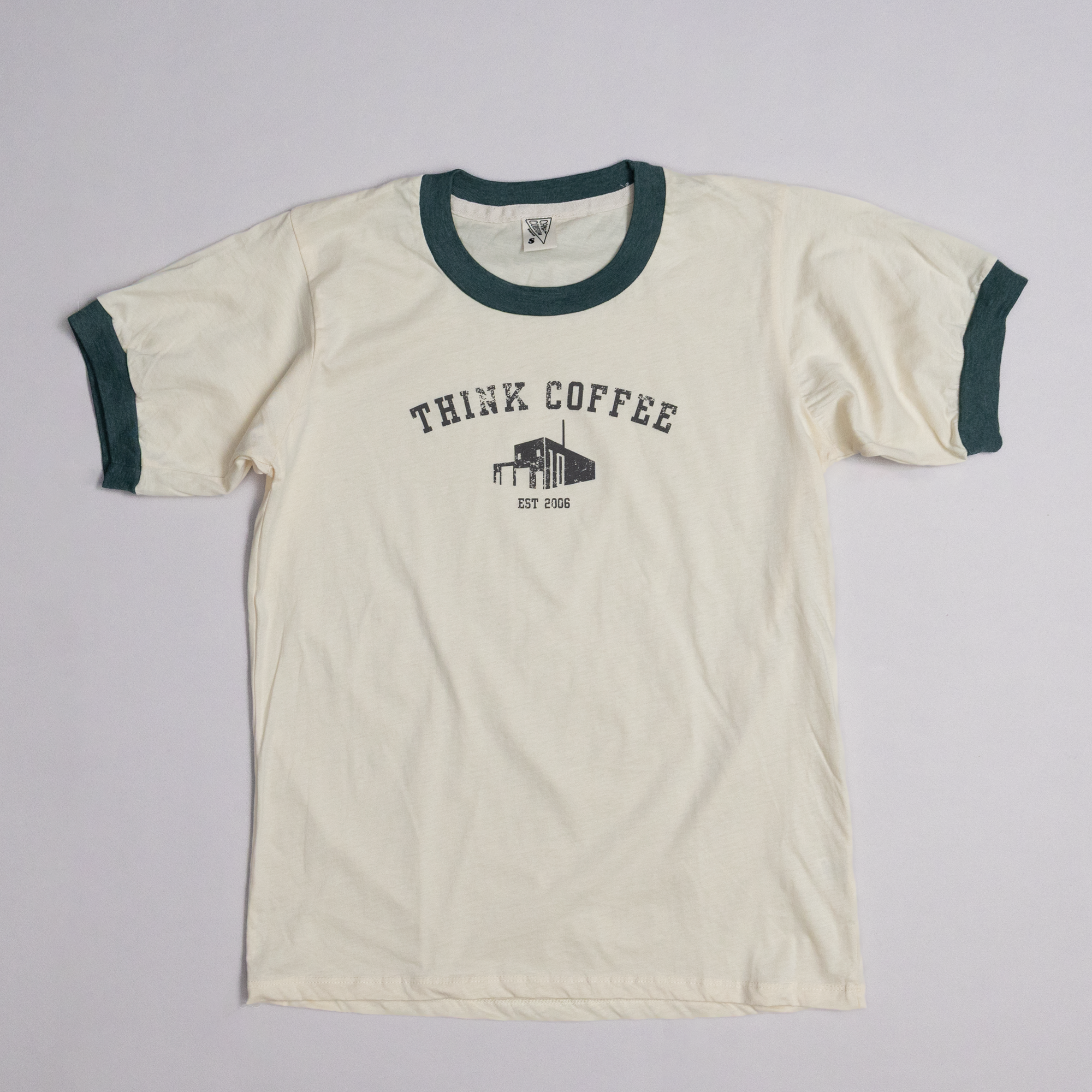 Beige t-shirt with 'Think Coffee' graphic on a gray background