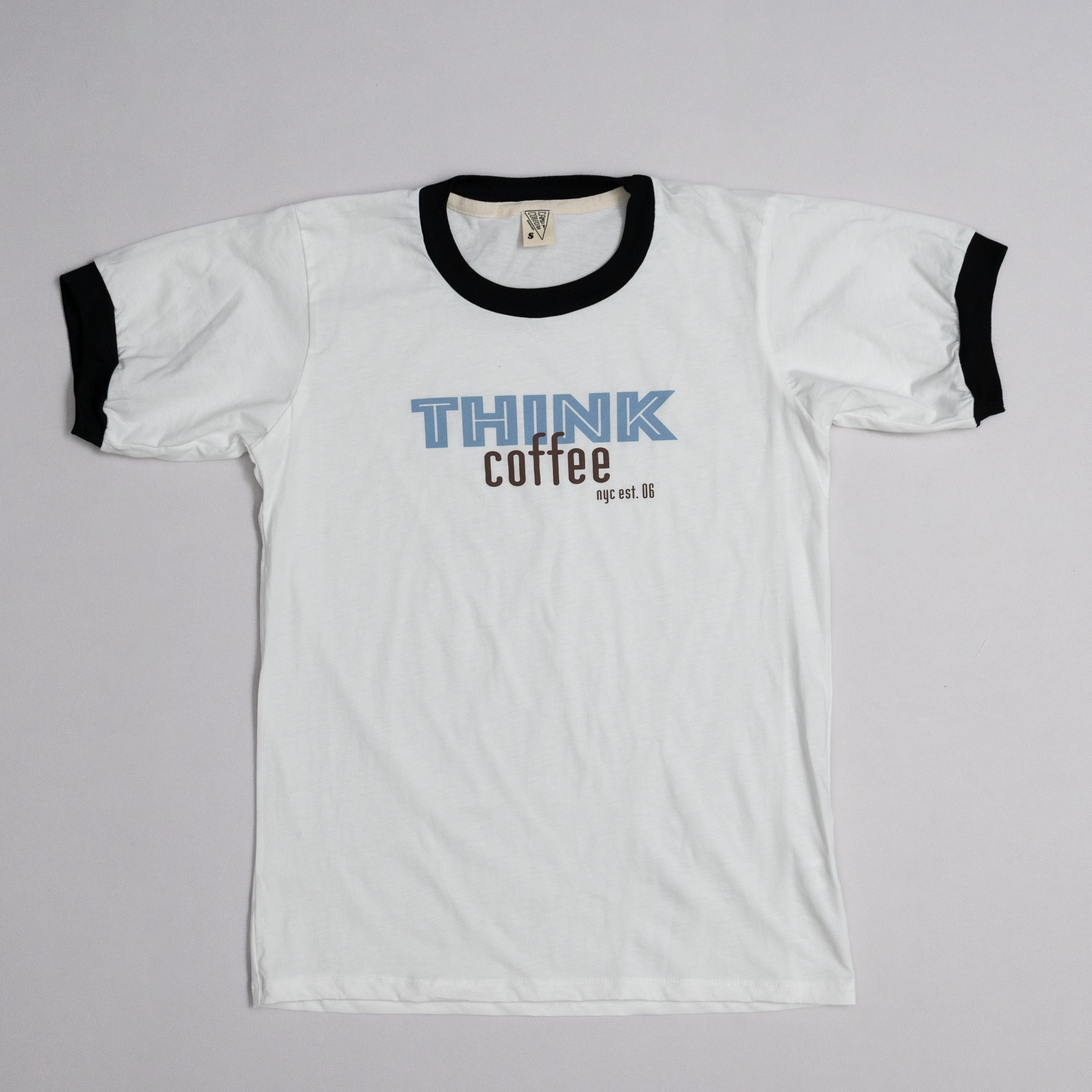 White t-shirt with black ringer sleeves and text on a gray background