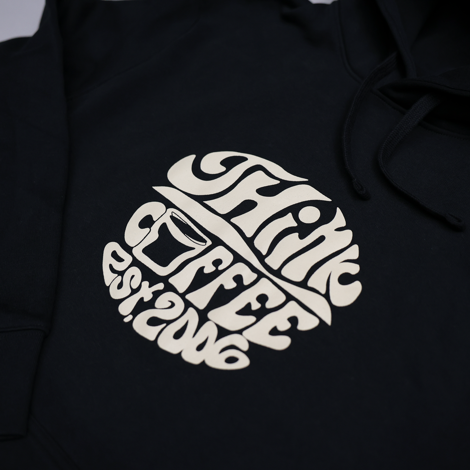 Black hoodie with a white logo on a dark background