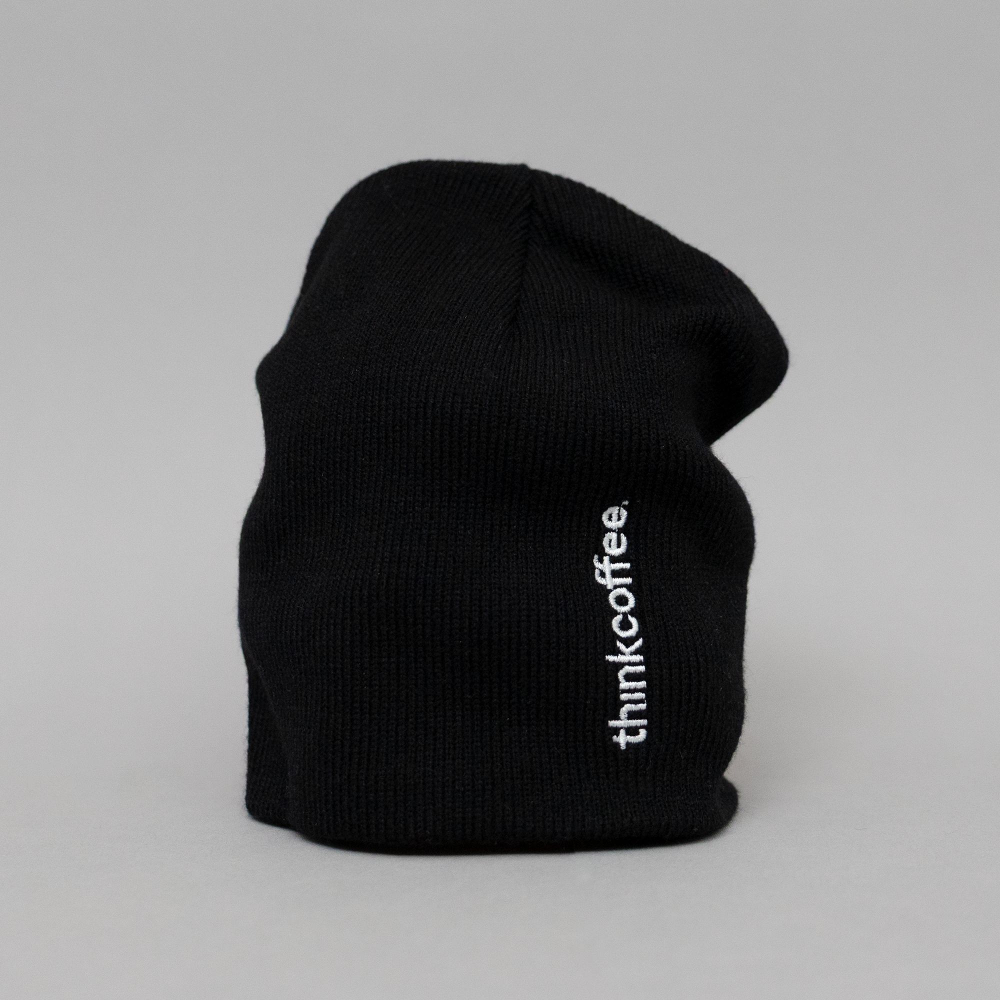 Black beanie with 'thinkcoffee' logo on a gray background