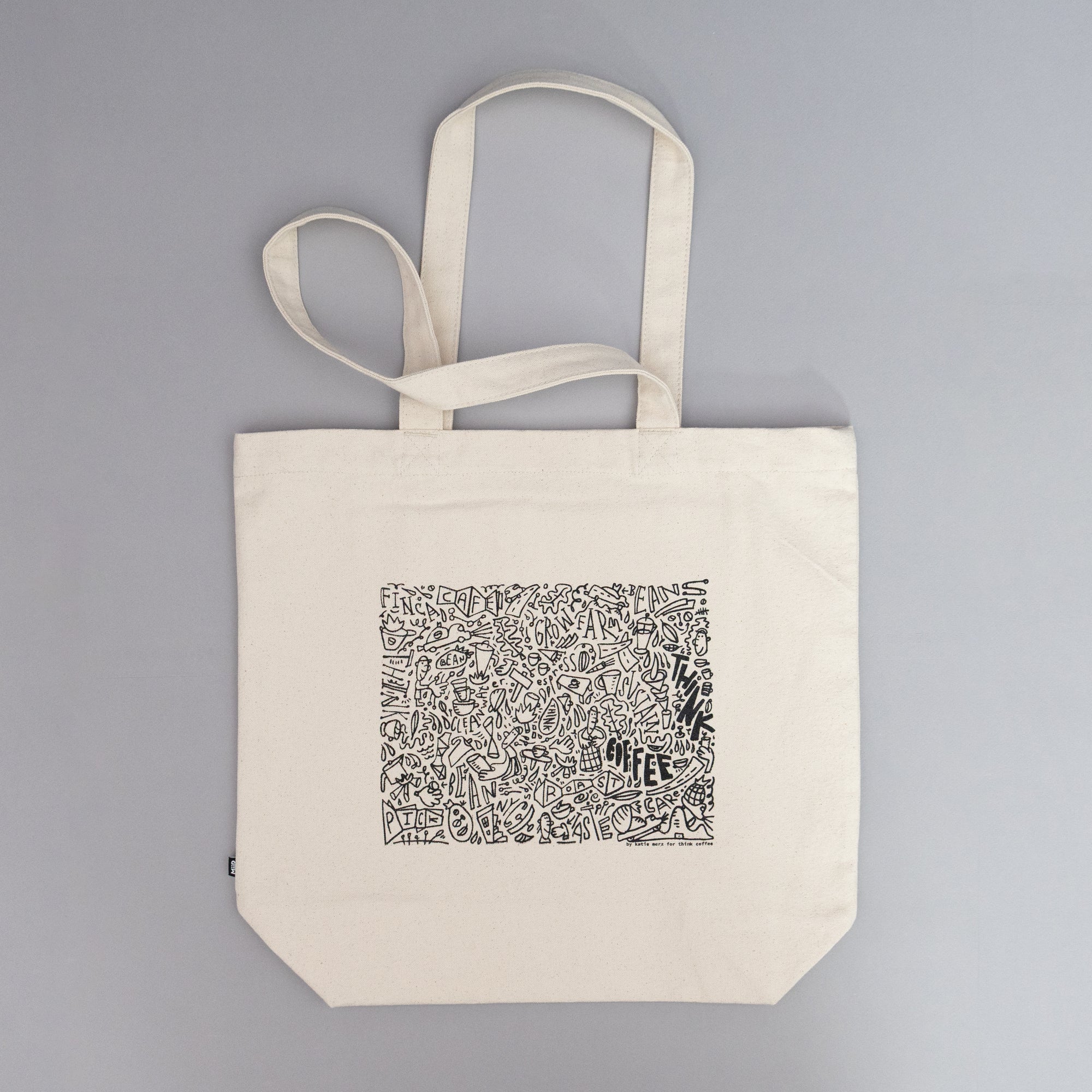Beige tote bag with black and white pattern. Think Coffee Merch